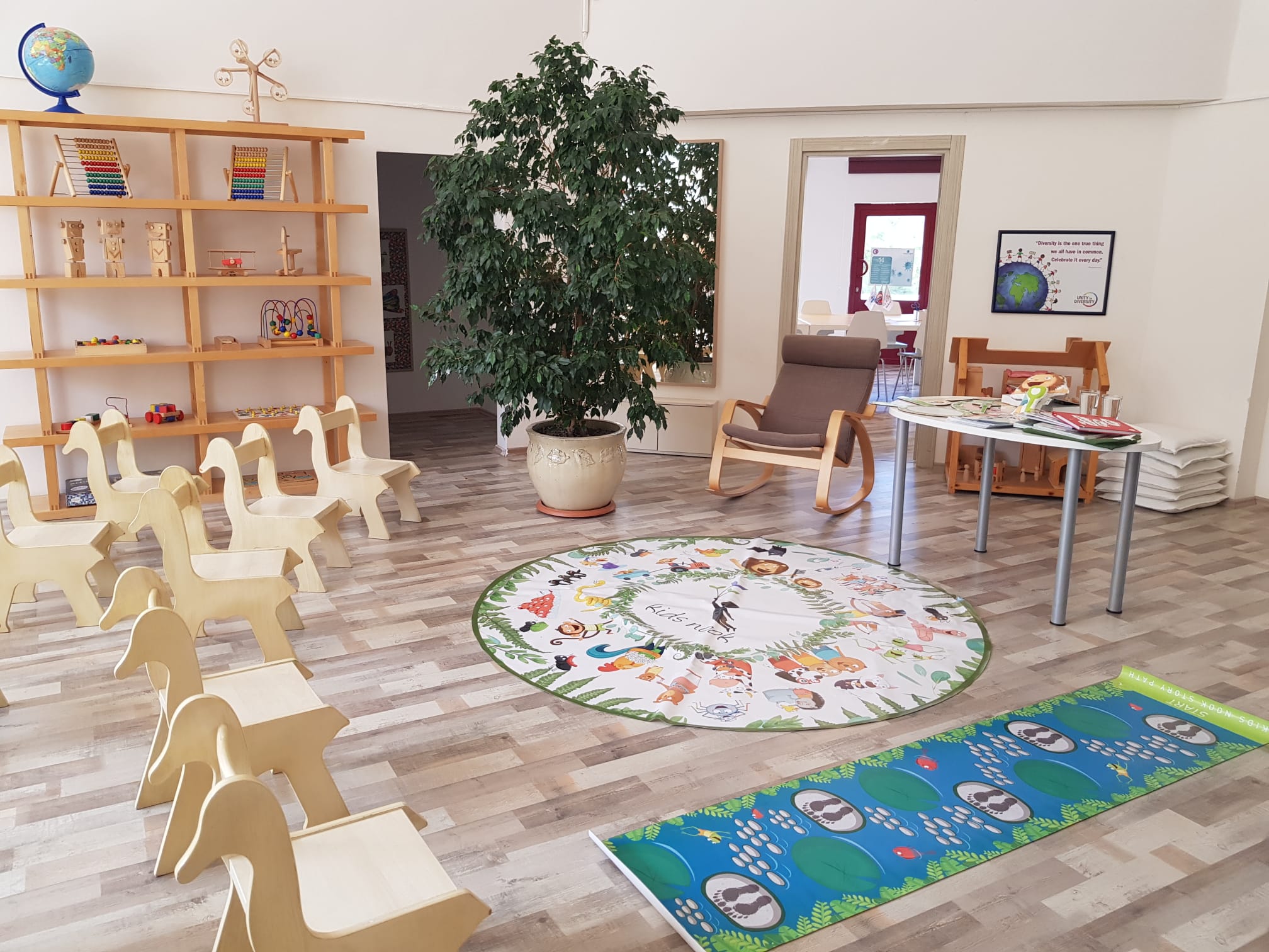 Kidsnook sınıfı — ahşap materyaller, kitap rafları ve hikâye halısı