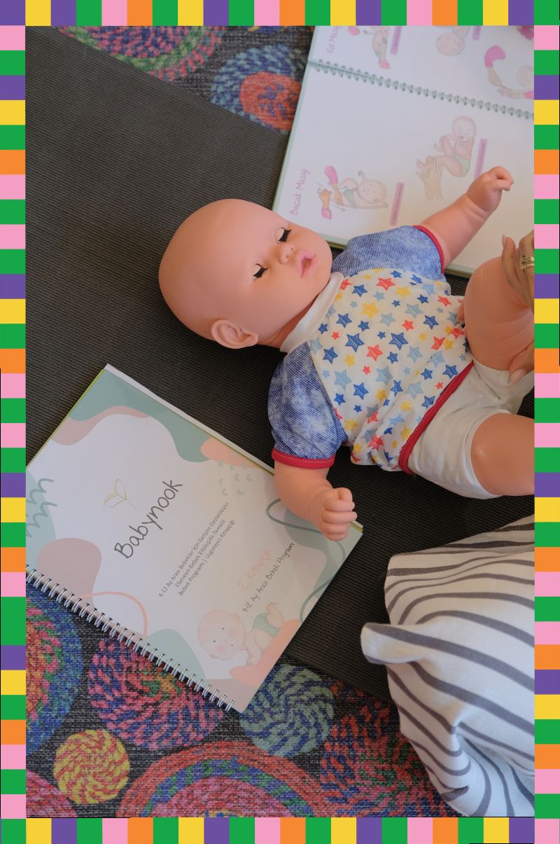 Babynook seansında yer minderinde bebek ve Babynook programı defteri